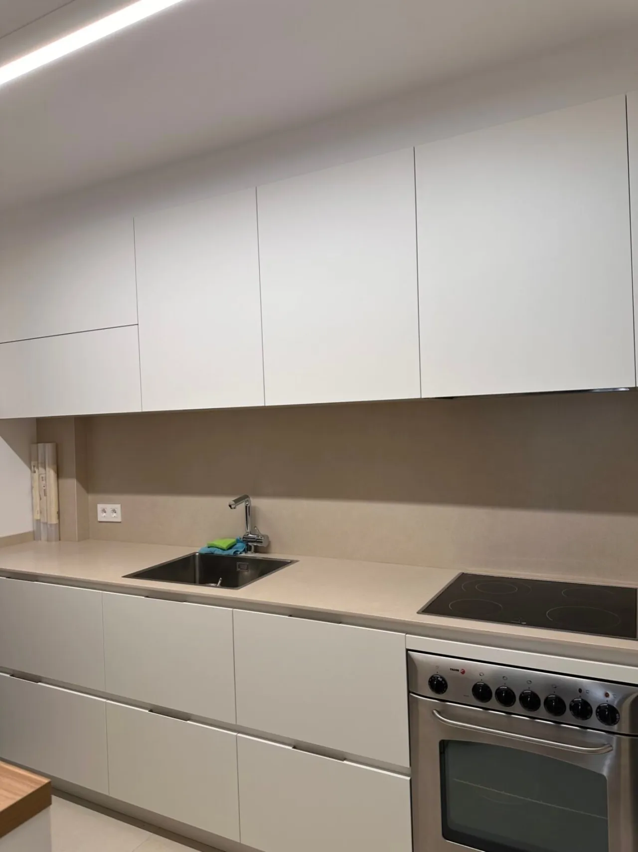 Cocina blanca con armarios altos y encimera clara