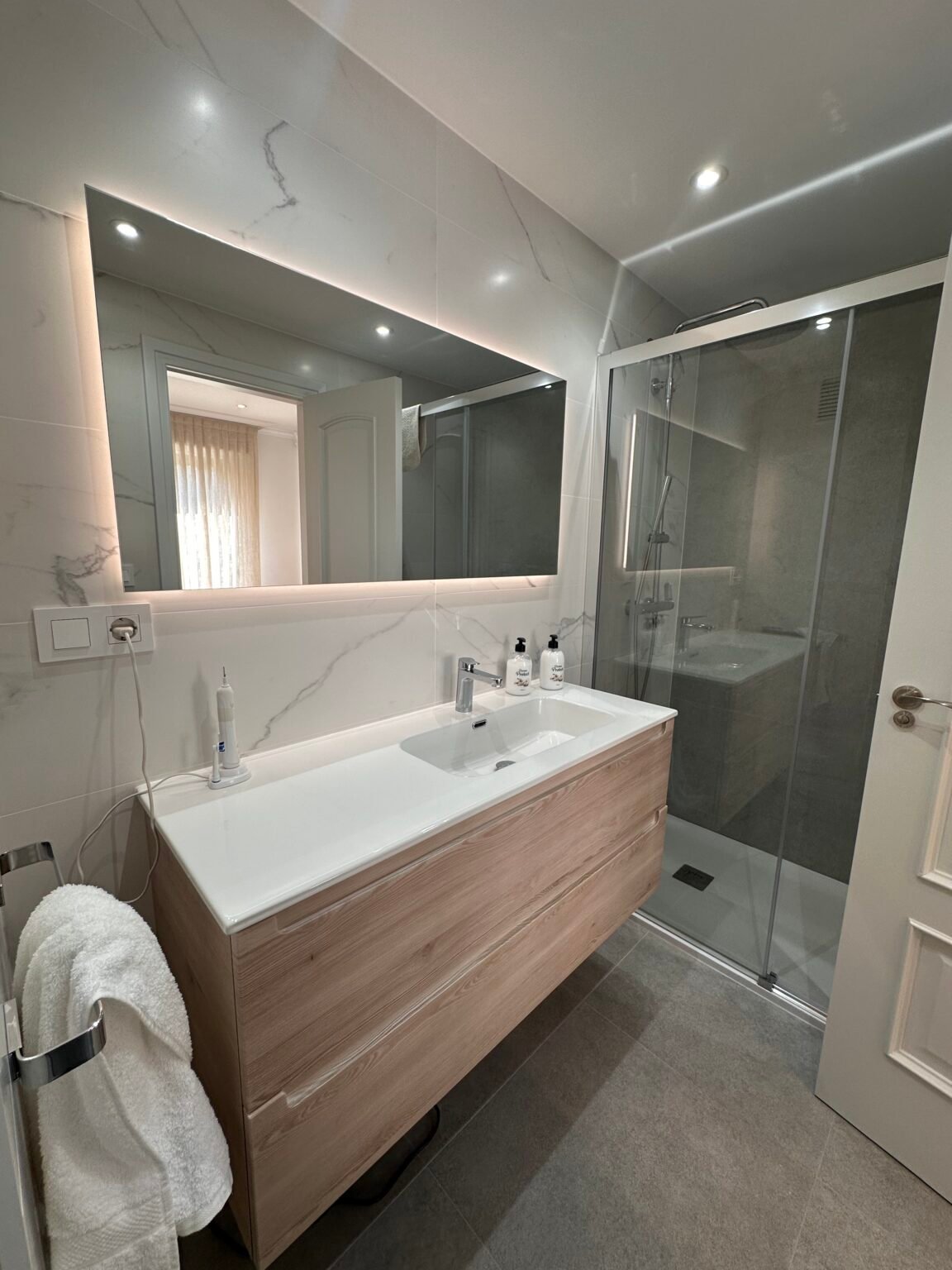 Reforma de baño, acabados en madera y luz cálida