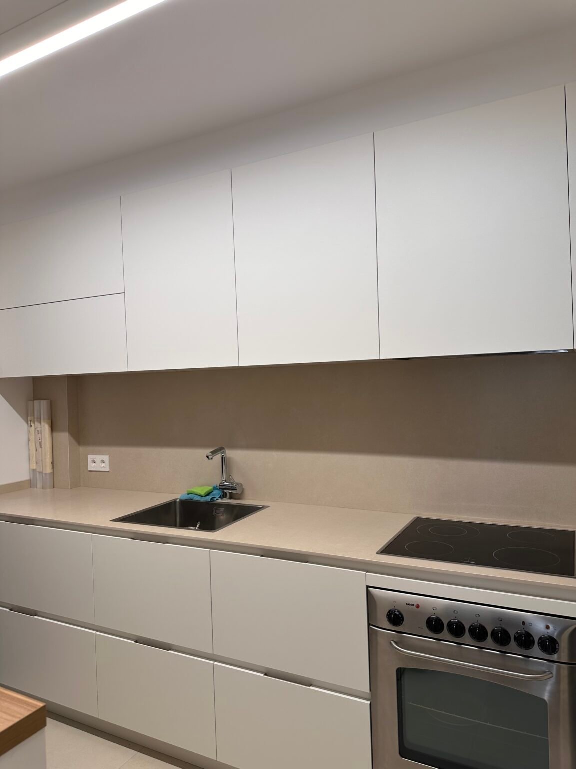 Cocina reformada por Reformas Casal con mobiliario blanco y encimera clara